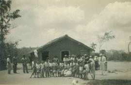 Grupo de pessoas em frente à residência rural